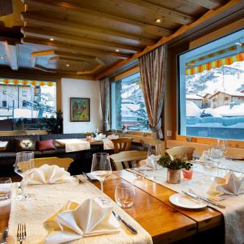 Bright, inviting dining room with large windows and a view of the snow-capped mountains.