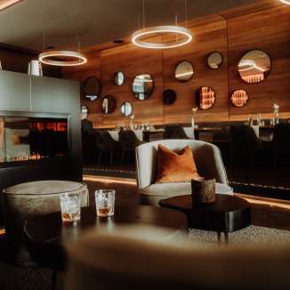 Stylishly furnished restaurant Tenn in the Hotel kommod with fireplace, elegant lighting and cozy lounge furniture.