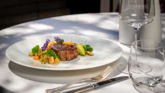 Exquisitely prepared meat course with vegetables and flowers on the terrace of the Park Hotel Sonnenhof in Vaduz, Liechtenstein
