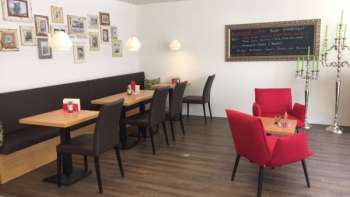  Cozy café with modern seating, decorative picture wall and warm wooden floor