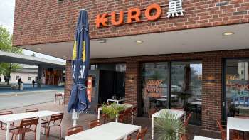 Exterior view of Restaurant Kuro with wine tables in the outdoor area in the foreground