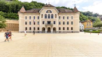 Vaduz government building with bright façade and square in front.