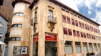 Exterior view of the PostMuseum with its striking natural stone façade and red shutters in the center of Vaduz.
