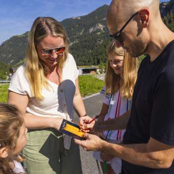 Family enters minigolf points in a scorecard