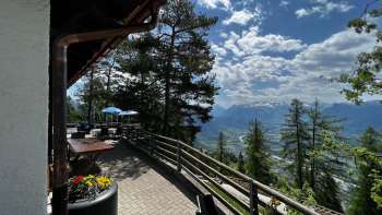 Sun terrace of the Matu mountain inn with a view of the Rhine Valley and the surrounding mountain landscape.