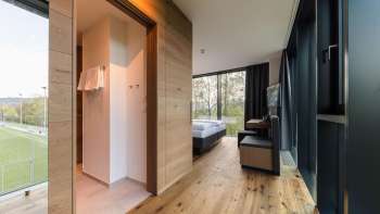 A bright room at the Hotel Kommod with elegant hardwood floors and a view of the greenery
