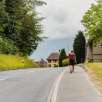 Hikers with rucksacks on the sidewalk in Schaanwald at the start of the stage to Ruggell on the Liechtenstein Trail.
