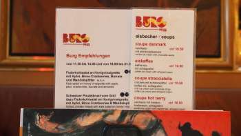 Brasserie Burg menu in front of a colorful mural - culinary delights and art in the heart of Vaduz.