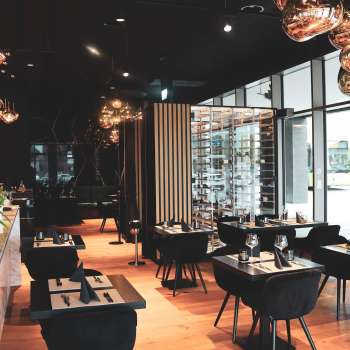 Modern restaurant interior with elegant black tables and chairs