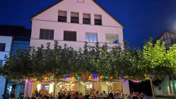 Atmospheric evening shot of the St. Martins Pub with illuminated terrace and colorful fairy lights