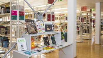 Bright entrance area of the Liechtenstein National Library with modern bookshelves and exhibition space for new publications