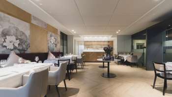 Spacious dining area with an elegant atmosphere, large tables and modern seating