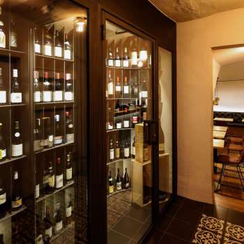 Modern wine cabinet with fine bottles in the stylish WY Weinbar, view into the adjoining tasting room.