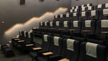 Modern movie theater in the Skino Schaan with comfortable seats, small tables and subdued lighting.