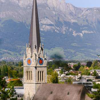 View of St. Florin's Cathedral in Vaduz with mountains in the background