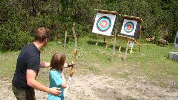 A child concentrates as he draws a bow during an archery session in Malbun