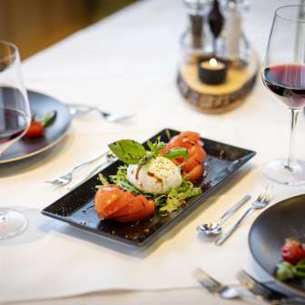 Fresh tomato and mozzarella salad with red wine on a laid table at the JUFA Hotel Malbun
