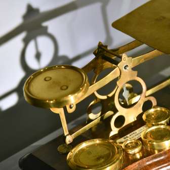 Close-up of a historic, gold-plated letter scale in the PostMuseum in Vaduz - a detailed exhibit from Liechtenstein's postal history.