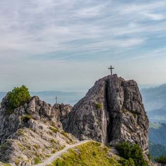Two summit crosses on the rocks of the Drei Schwestern mountain chain with views over the Rhine Valley along Route 66 in Liechtenstein