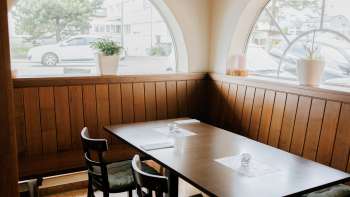 Inviting dining room with bright windows and rustic wooden furnishings