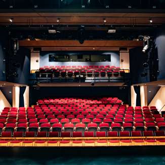 View from the stage of red rows of seats and lighting technology in the modern auditorium of the TAK Theater Liechtenstein