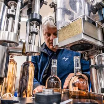 Employee monitors the machine filling of wine bottles in a winery in Liechtenstein