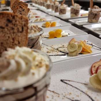Richly laid table with small dessert glasses, fruit and garnish for a sweet buffet