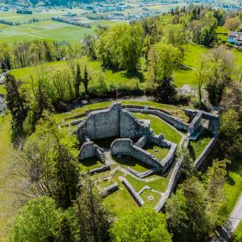 Aerial view of the castle ruins of Schellenberg, surrounded by dense forest and meadows.