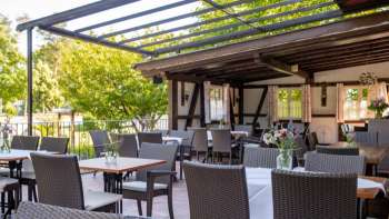 Inviting outdoor area with rustic wooden interior, decorated tables and blooming flowers