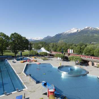 General view of the Mühleholz outdoor pool with several pools and a magnificent Alpine panorama in the background.