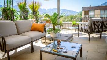 Terrace seating area with cocktails and views of the Liechtenstein Alps