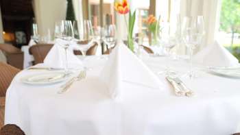 Festive table setting with white tablecloth and fresh tulip