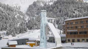 View of the ice tower in Malbun with snow-covered forest in the background