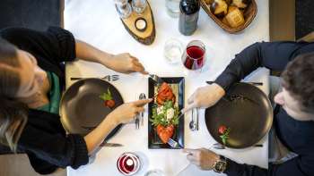 A couple enjoys an appetizer with tomatoes and mozzarella