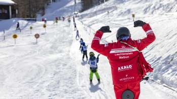 Ski course at Malbi Park in Malbun with colorful helmets and dedicated instructors - safe learning in a child-friendly environment