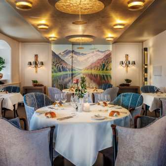Round tables with wine glasses and candles in the elegant dining room of the Park Hotel Sonnenhof in Vaduz, Liechtenstein