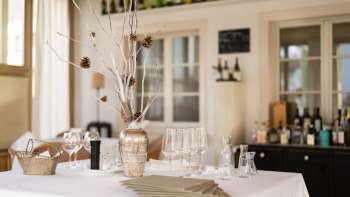 Decorative bar in the Vivid restaurant with stylish glasses, bottles and natural mood lighting