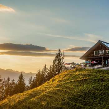 Gadafura hut on a sunny mountain meadow with a view of the mountains and sunset