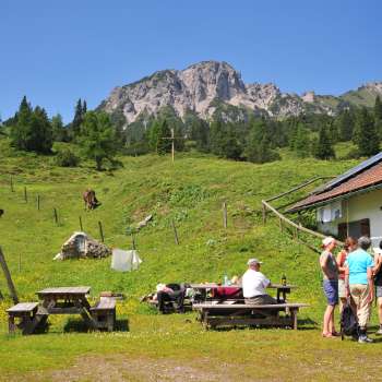 View of the mountains from Alpe Guschg, where several people take a break and enjoy the view