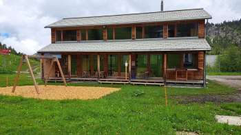 Exterior shot of the Malbipark-Bistro with a playground and meadow in the foreground