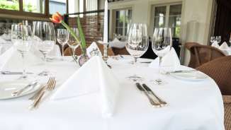 Stylishly laid table with glasses, cutlery and white tablecloth in the upscale restaurant Vivid in Triesen, Liechtenstein.