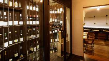 Modern wine cabinet with fine bottles in the stylish WY Weinbar, view into the adjoining tasting room.