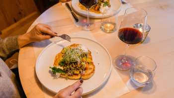 Close-up of a stylishly prepared main course with red wine at Gasthof Au.