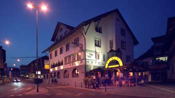 Exterior view of the Adler restaurant in the evening, with traditional façade and atmospheric lighting
