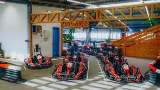 Several red e-karts on the indoor kart track in Nendeln, ready for the next race
