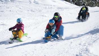 Family-friendly tobogganing fun on the snow-covered toboggan run in Malbun - children and adults enjoy the descent in Liechtenstein's winter paradise.