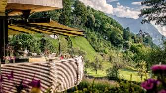 Terrace of the Park Hotel Sonnenhof in Liechtenstein with a view of Vaduz Castle and the surrounding Alpine landscape