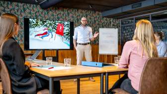 Modern conference room with participants in a business meeting, presentation about skiing in Liechtenstein on the screen