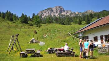 View of the mountains from Alpe Guschg, where several people take a break and enjoy the view