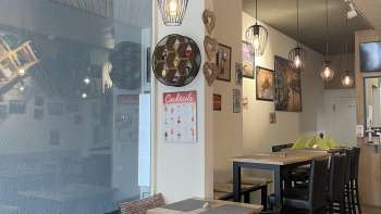 Stylishly furnished dining room with black wooden furniture, wooden floors and creative wall decorations